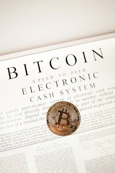 Bitcoin cryptocurrency coin on top of its white paper. Digital currency concept.