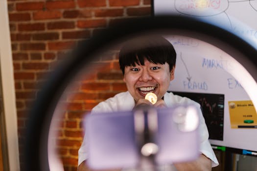 Excited Asian man presenting lively Bitcoin discussion with a smile indoors.